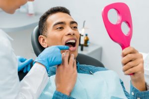 patient looking at smile with hand mirror