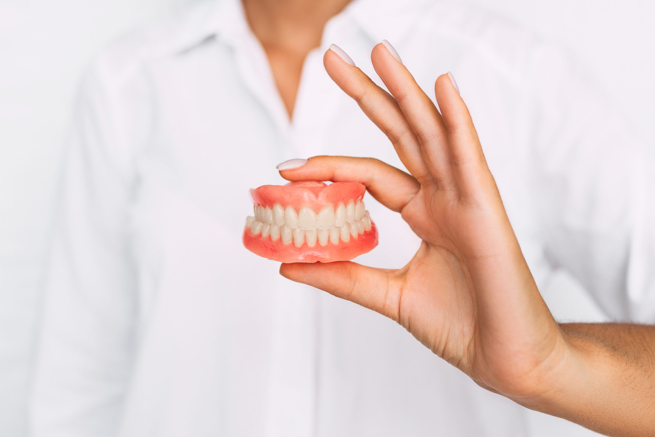 The,Dentist,Is,Holding,Dentures,In,His,Hands.,Dental,Prosthesis