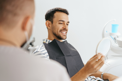 Male,Dentist,Discussing,With,Happy,Patient,